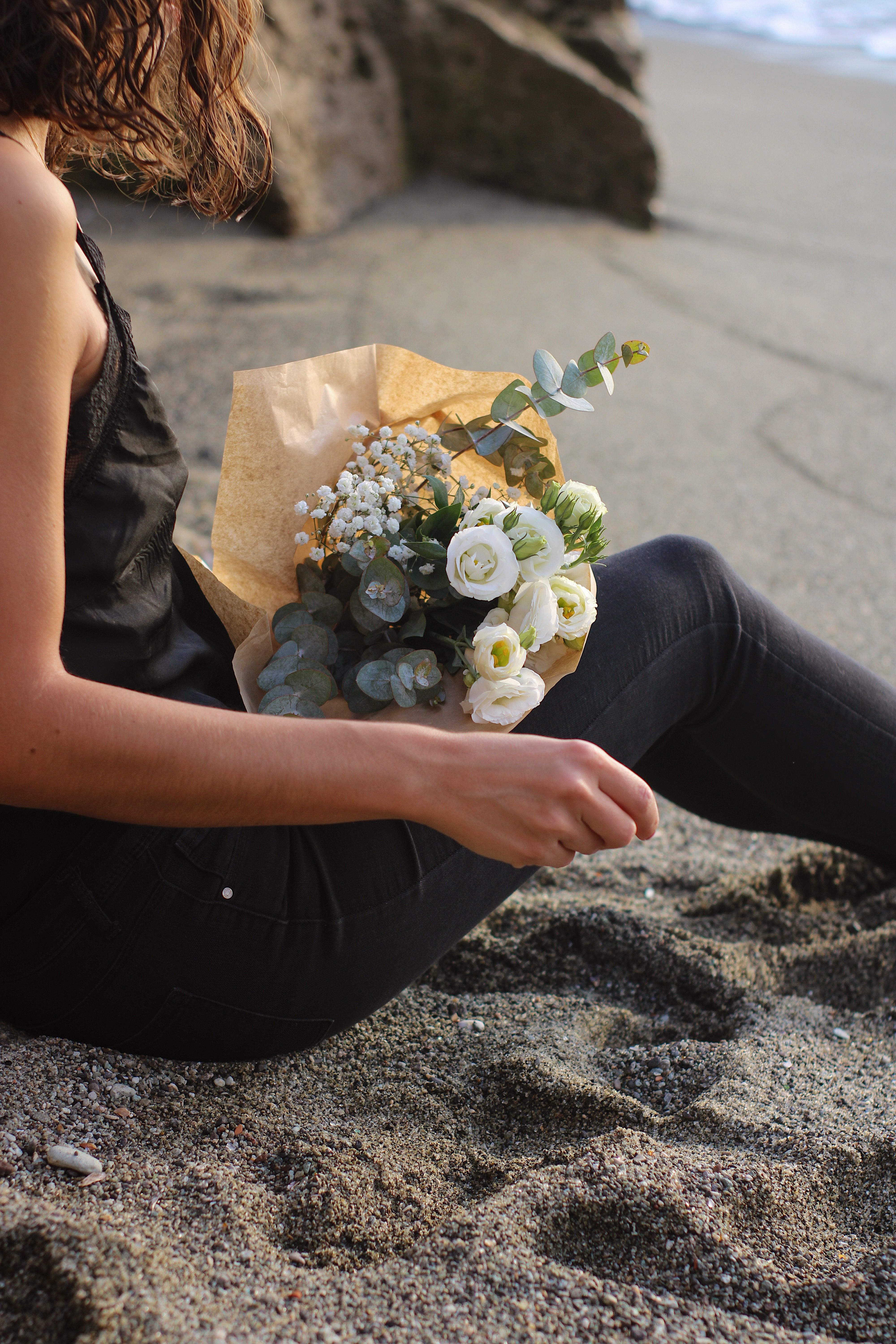 Woman Sitting with Bouqeut on Beach · Free Stock Photo