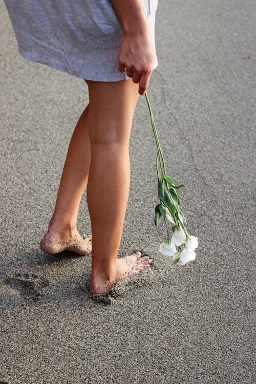 Woman Legs on Sandy Beach