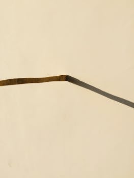 A minimalist abstract composition of a wall with a unique shadow pattern, enhancing simplicity.