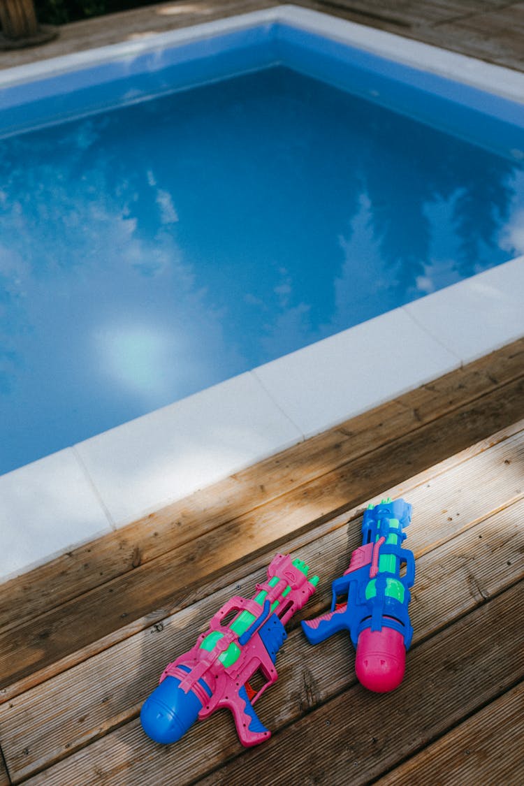 Toy Gun On A Wooden Surface Beside Pool 