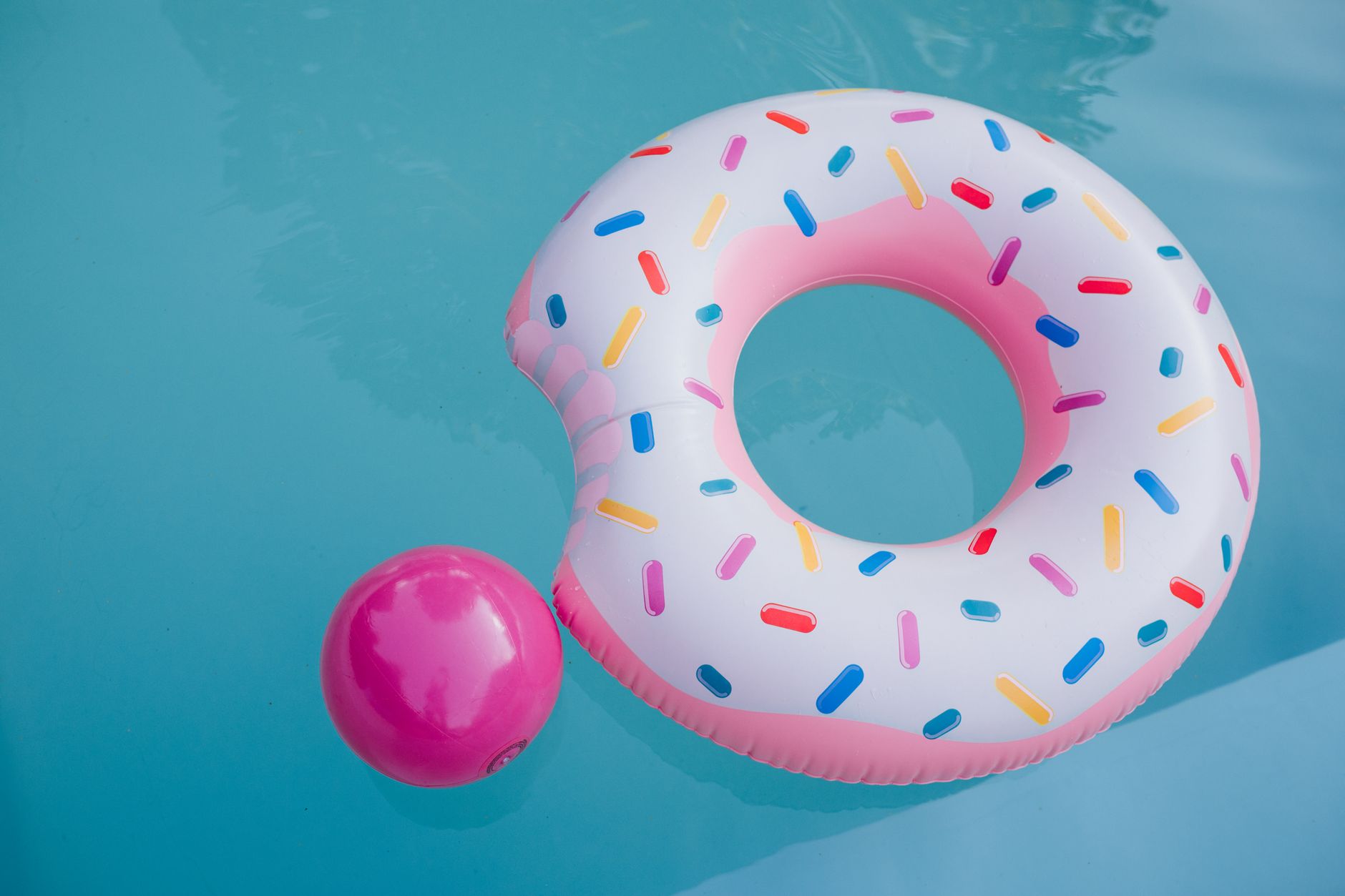 Inflatable pool floats on bright blue water, easily inflated with a portable air compressor for summer fun
