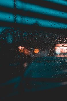 Artistic capture of rain droplets on a window at night in Oxford, highlighting urban bokeh effect.