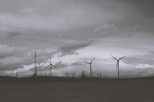 Silhouette of wind turbines against a cloudy sky, symbolizing renewable energy and sustainability.