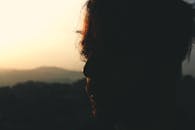 日出或日落时分，山上的光线勾勒出一个人影，捕捉到一种喜怒无常的氛围