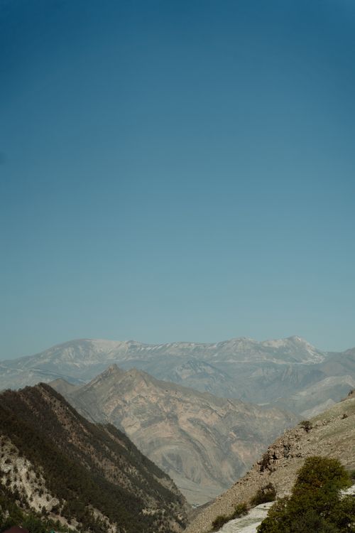 Free A breathtaking view of a vast mountain range with clear blue skies in the background, perfect for nature photography enthusiasts. Stock Photo