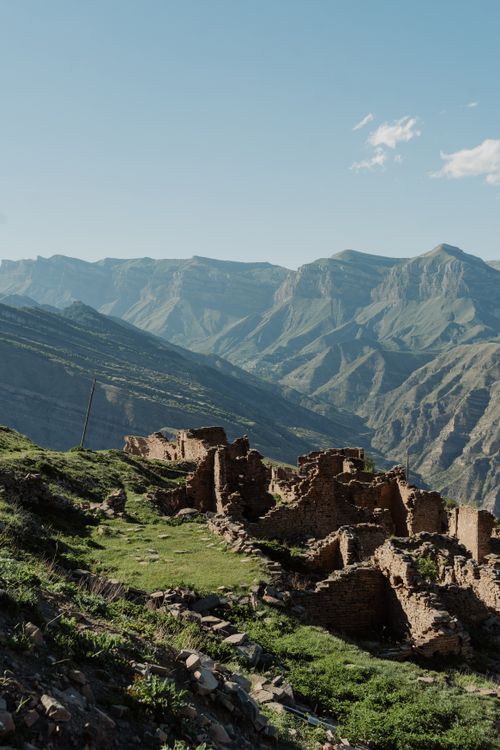 Free Explore the ancient ruins of Gamsutl set against the dramatic Caucasus mountains. Stock Photo