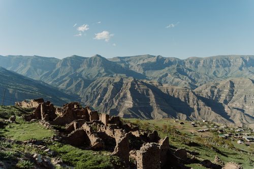 Free A stunning landscape of expansive mountain ranges and ancient ruins under a clear blue sky. Stock Photo