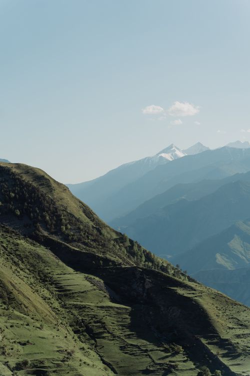 Free Lush green mountain ranges under a clear blue sky offer a breathtaking nature scene. Stock Photo