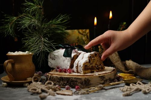 Free A festive Christmas cake setting with pine branches and candlelight ambiance. Stock Photo