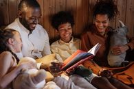 Father With Mother Reading Book to Kids