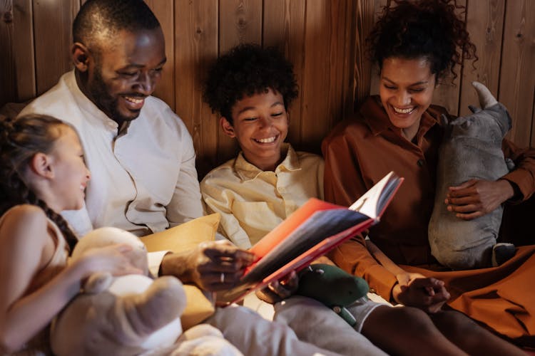 Father With Mother Reading Book To Kids