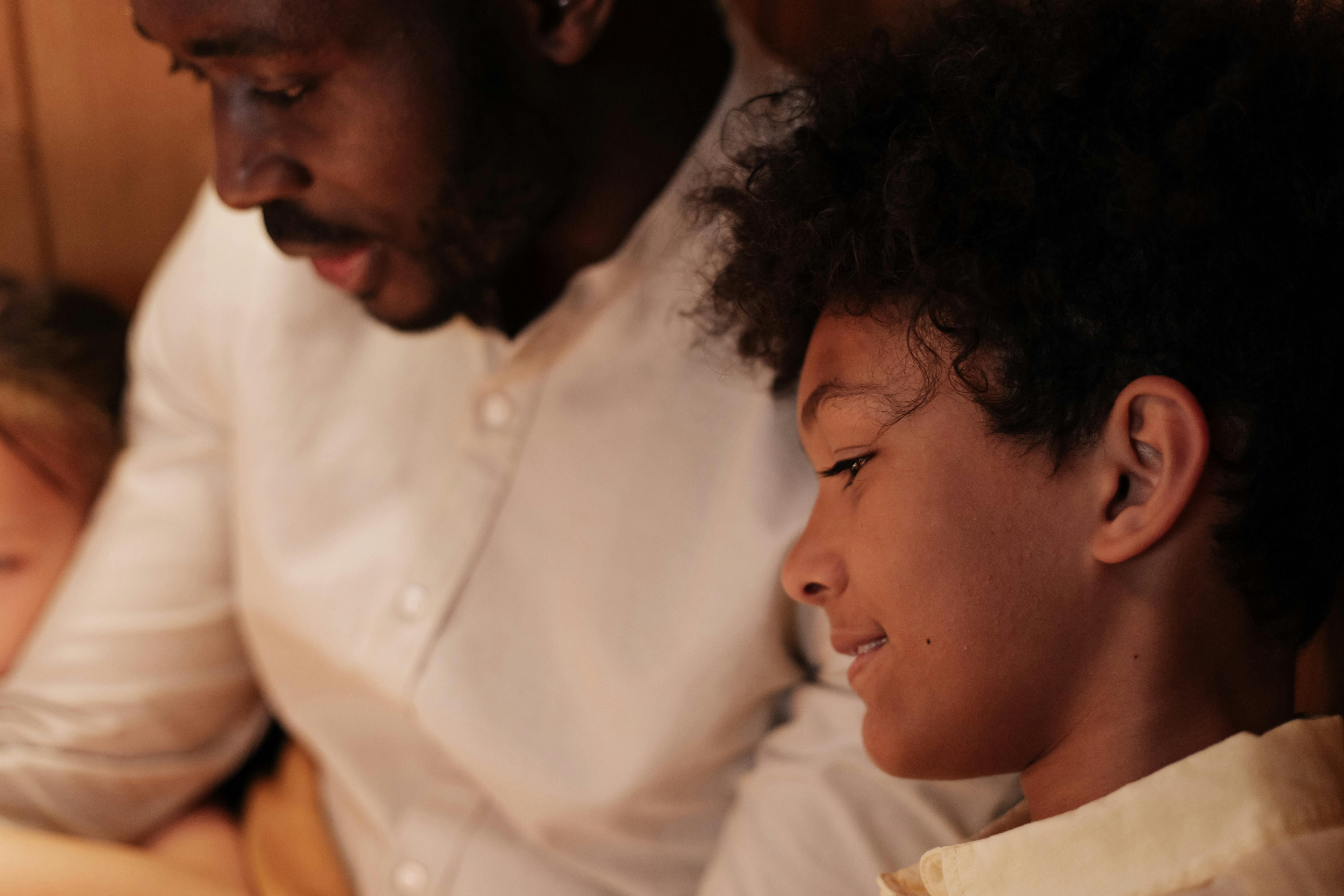 A father and son sharing a bonding moment while reading at home.