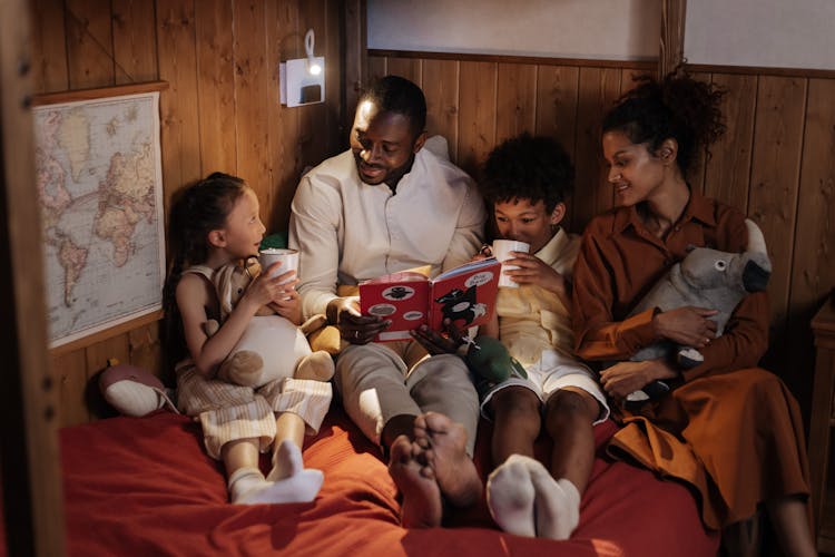 Father With Mother Reading Book To Kids