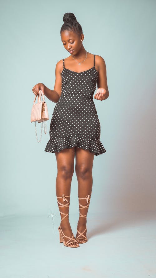 A Woman in Black Polka Dot Dress Holding Her Bag