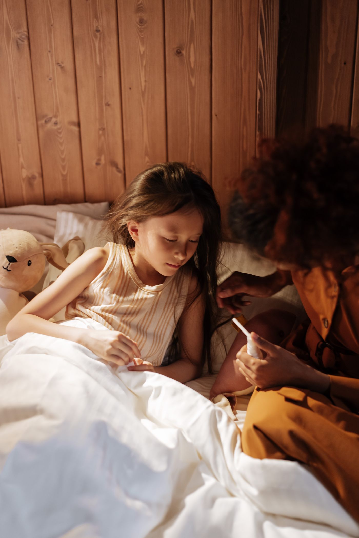 Mother caring for an unwell child and checking their temperature