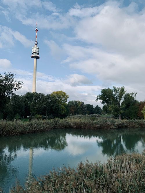 Free A peaceful lakeside scene featuring a tall observation tower and lush greenery. Stock Photo