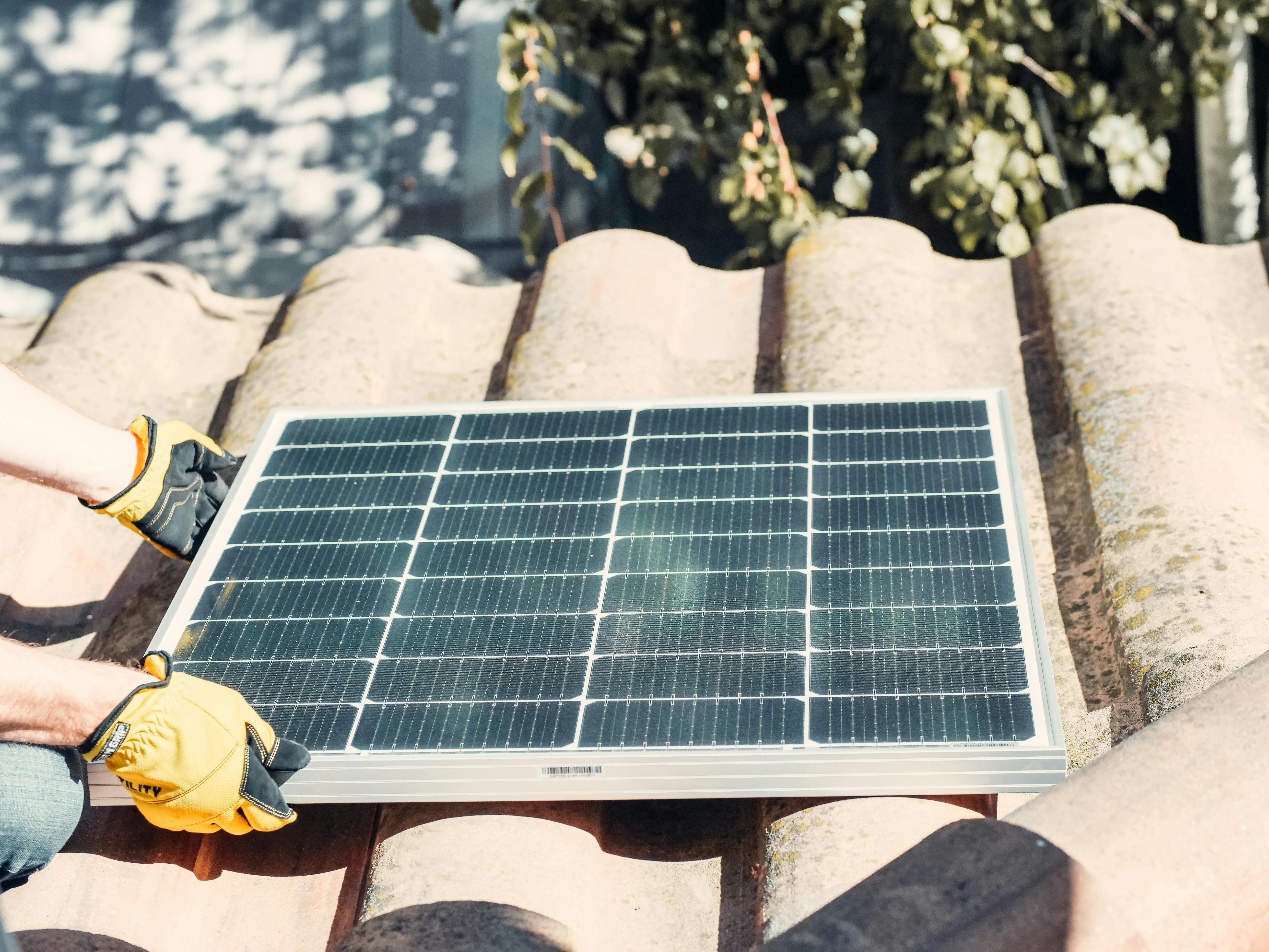 black solar panel on brown roof tiles