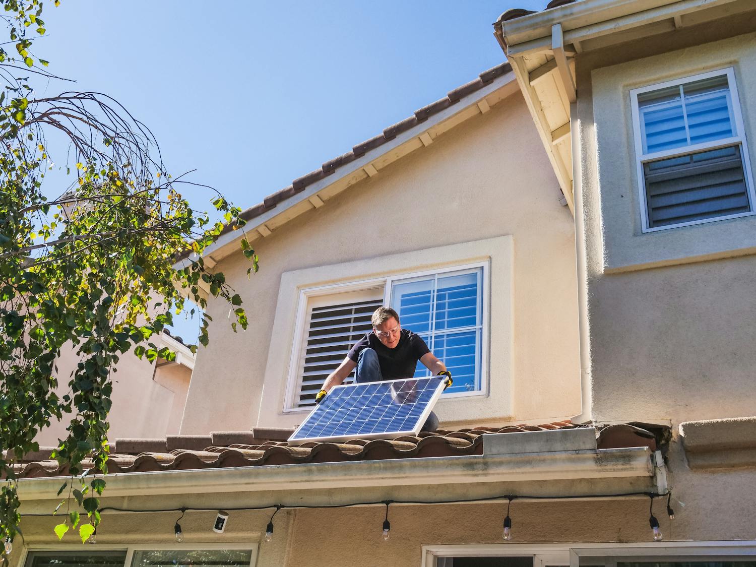 Technician installing solar panels on rooftop
