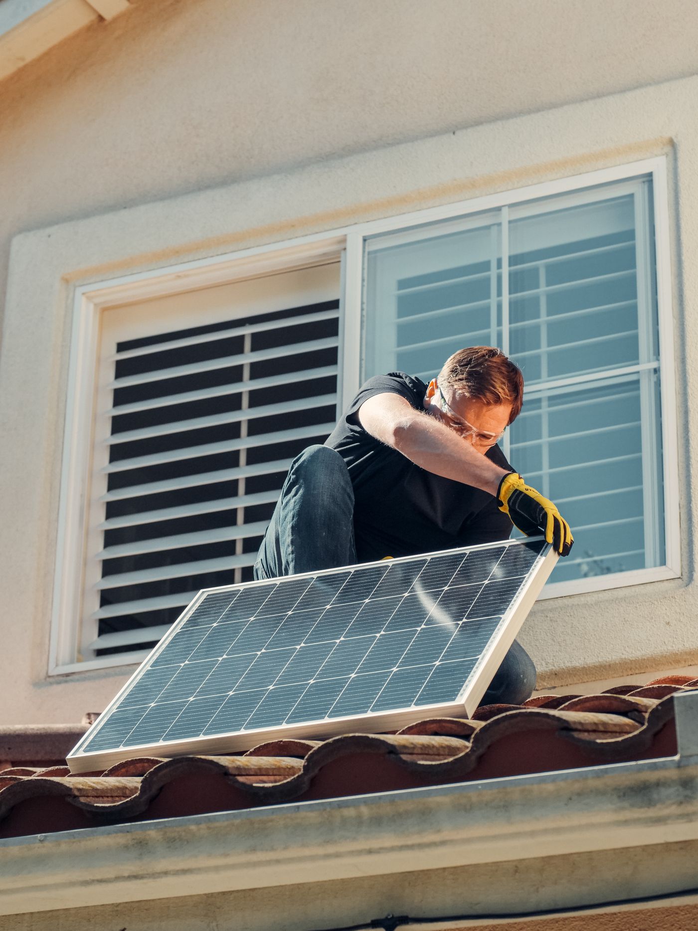 Solartechniker montiert ein Photovoltaikmodul auf einem Hausdach