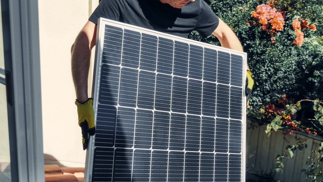 Tecnico che installa un modulo fotovoltaico sul tetto