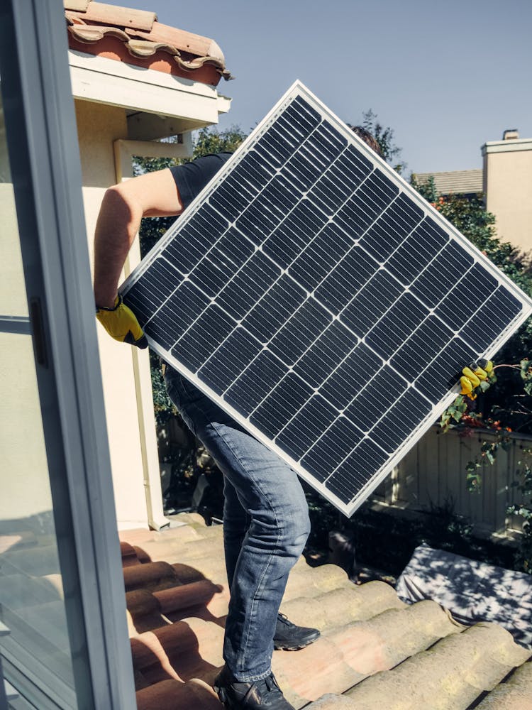 A Person Carrying A Solar Panel