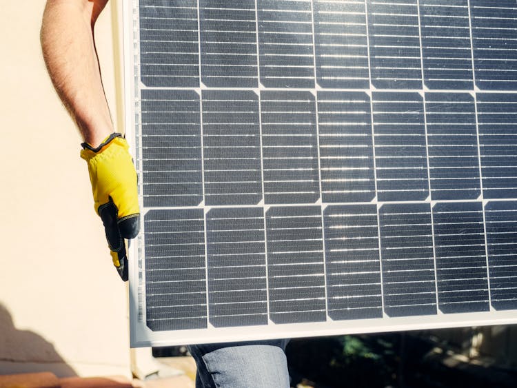 A Person Carrying A Solar Panel