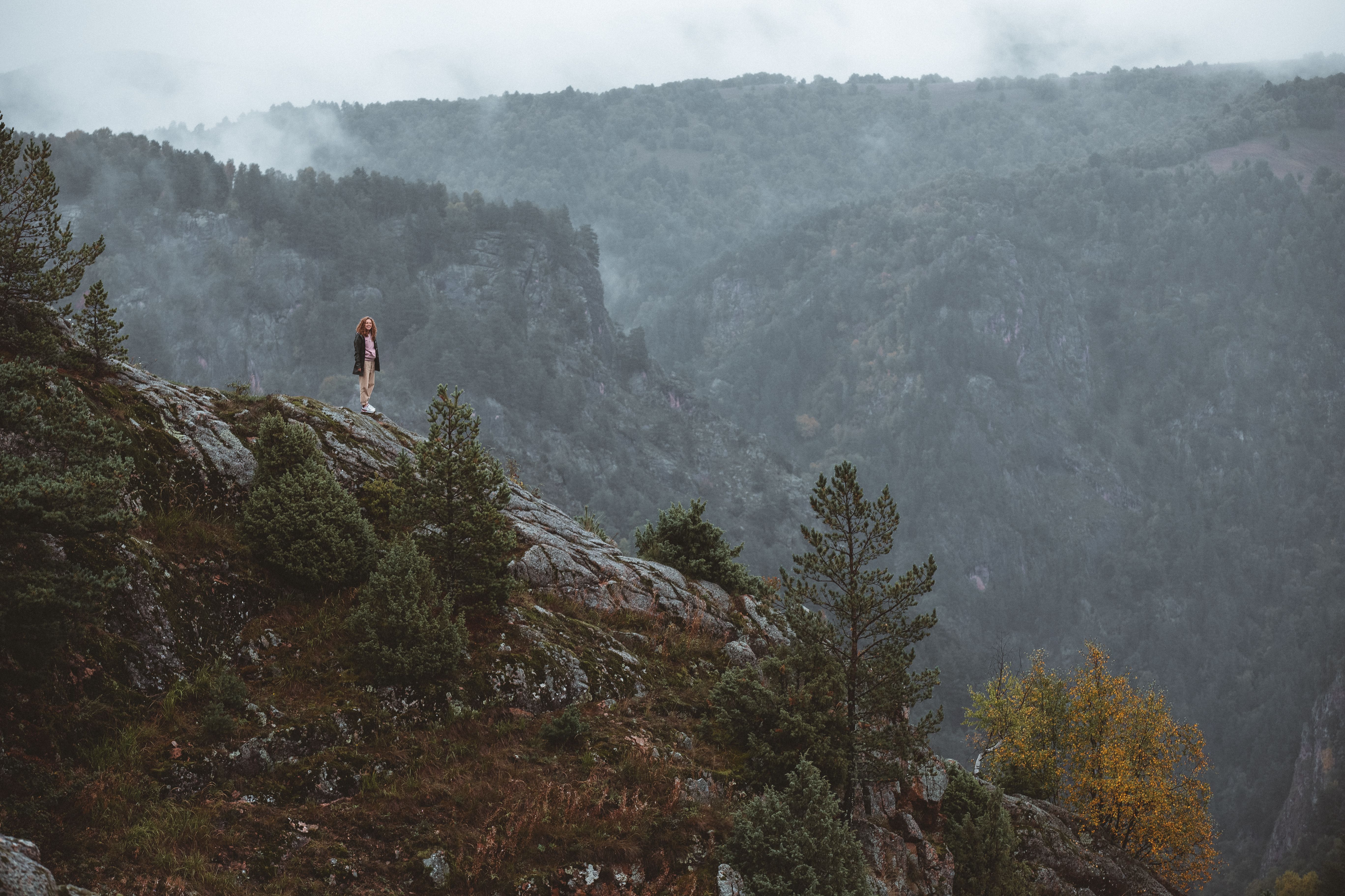 mountain landscape with fog and solitary figure praying in nature