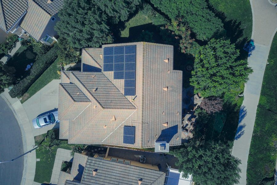 Top-down aerial view of a house with solar panels, showcasing modern renewable energy solutions.