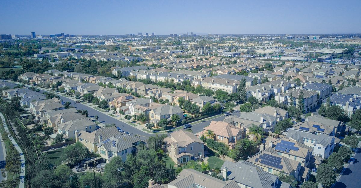 Aerial view of suburban homes in California with solar panels, showcasing sustainable living.
