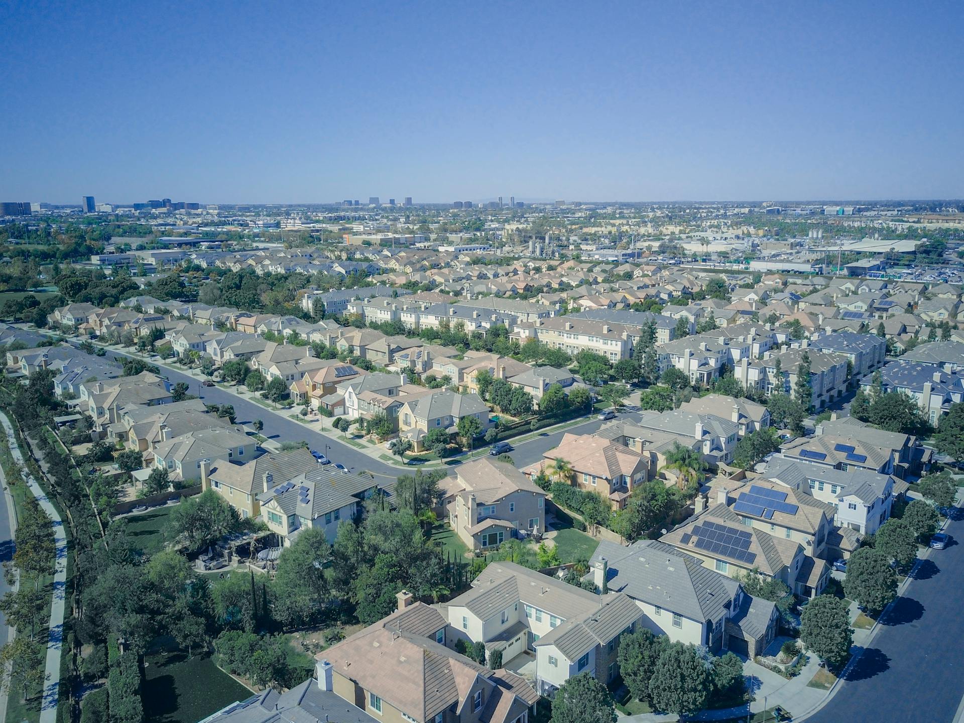 Aerial view of suburban homes in California with solar panels, showcasing sustainable living.