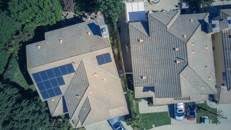rooftop solar panels installed on a suburban home with clear blue sky