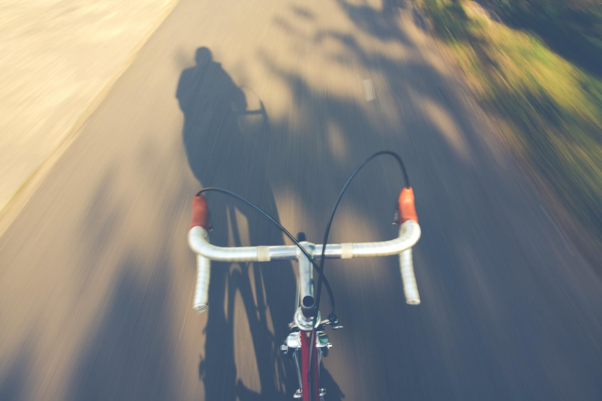 Blurred motion shot of a racing bike with a shadow on a sunny day.
