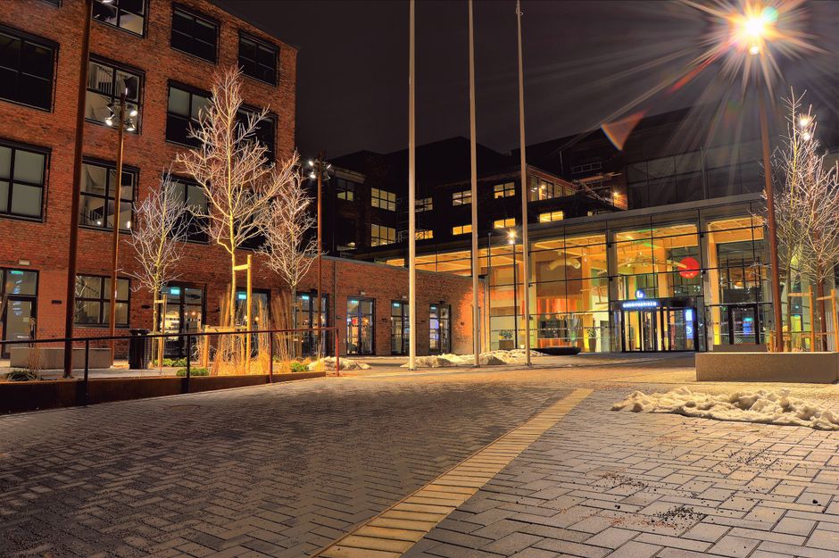 A modern architectural building illuminated at night, located in Sweden.