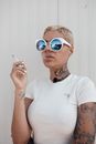 Blond Woman in Sunglasses Standing and Smoking Cigarette