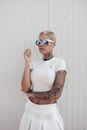 Blond Woman in T-shirt and Skirt Standing and Smoking Cigarette