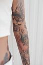 Unrecognizable Female Arm Covered with Tattoos