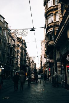Scenic view of an urban street lined with historic buildings and pedestrians at twilight.