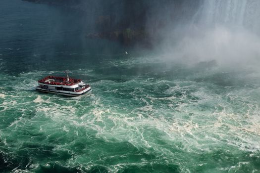 A tourist boat ventures close to the powerful waters of Niagara Falls in Ontario, Canada.