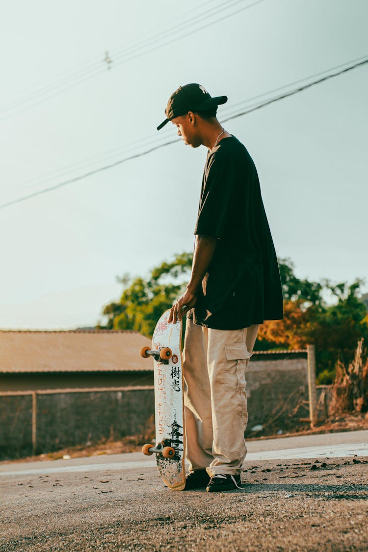 Man Standing And Holding Skateboard