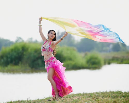 Free Graceful Dancer in Pink Costume holding a Colorful Sheer Fabric  Stock Photo