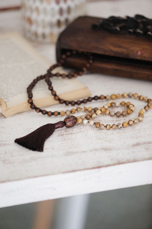 Free A detailed shot of prayer beads arranged on a rustic white table with open book background. Stock Photo