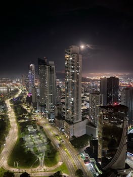 Breathtaking aerial view of a vibrant city skyline illuminated at night, showcasing towering skyscrapers.
