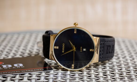 A Leather Strap Rado Wristwatch over Straw Surface