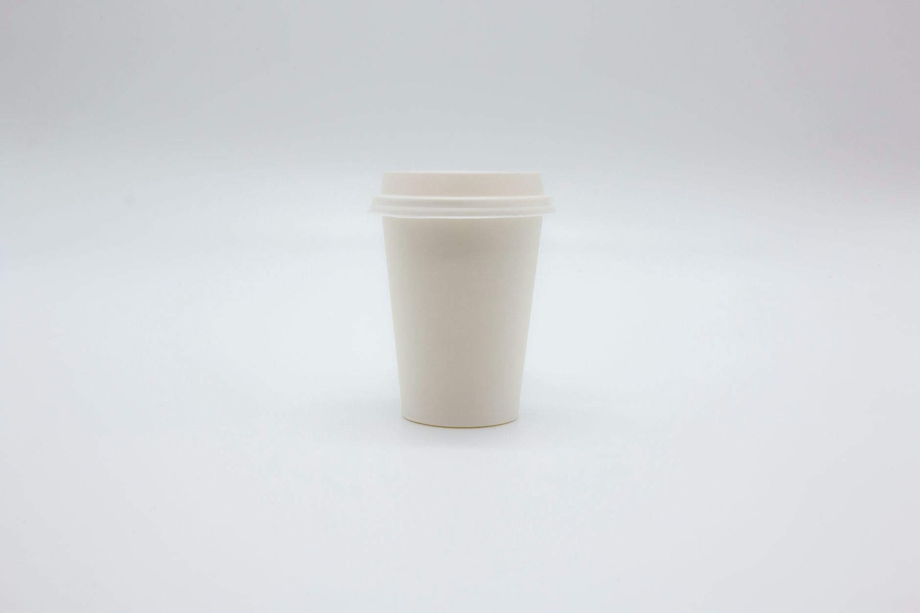 Paper Cup with Lid on White Surface