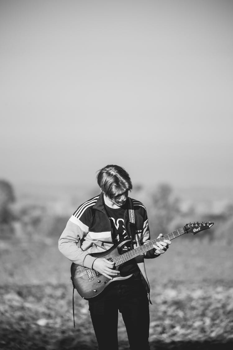 Man Standing And Playing The Guitar