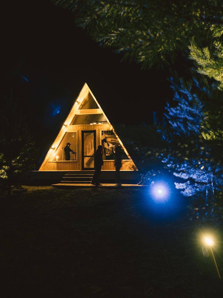 Illuminated Wooden Gable Cabin During Nighttime 