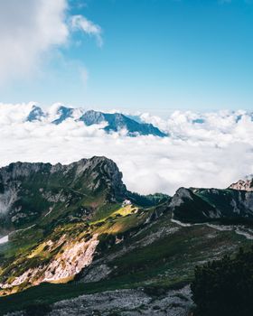 Breathtaking view of mountain peaks soaring above the clouds on a sunny day.