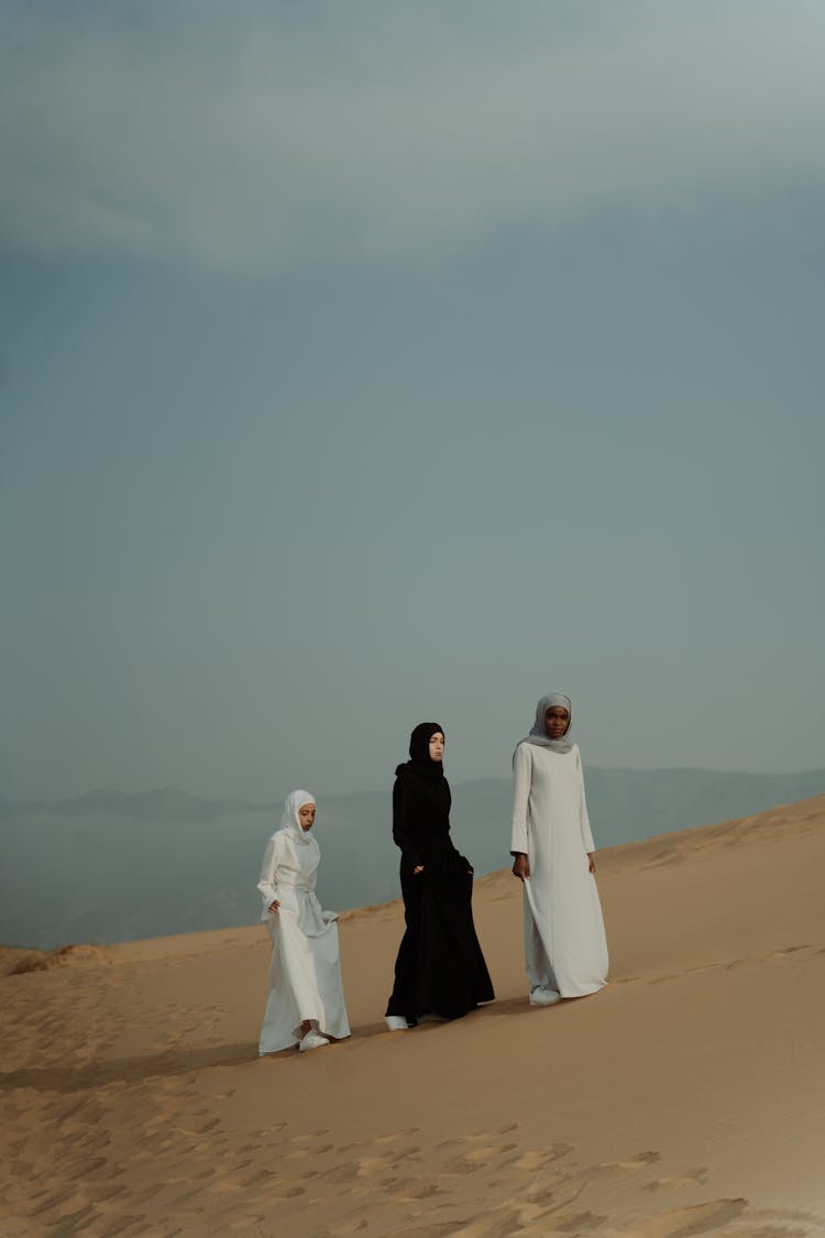 Women In Long Dresses Walking On The Desert