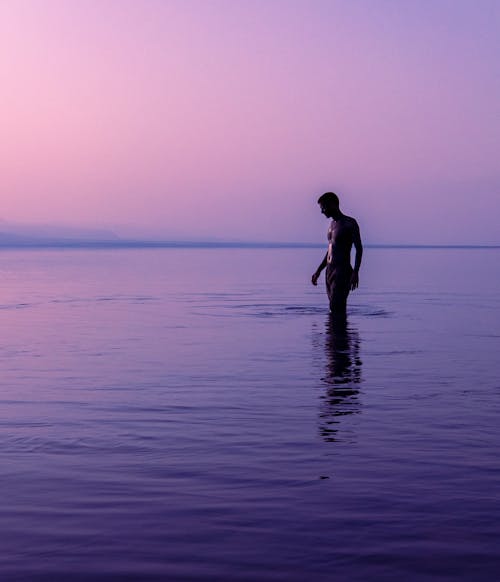 Man Walking in Water at Dawn