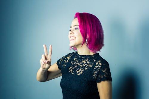 Free 
A Woman with Dyed Hair Making a Peace Sign Stock Photo
